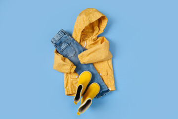 Childrens yellow raincoat, jeans and rubber boots. Set of kids clothes and accessories. Fashion...