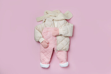 Puffer jacket, warm  pants and scarf on pink background. Set of baby clothes for  winter. Fashion...