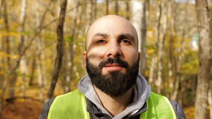 Close-up a man with a beard screams putting his hands to his mouth in the autumn forest trying to find a missing child. Rescue operation.