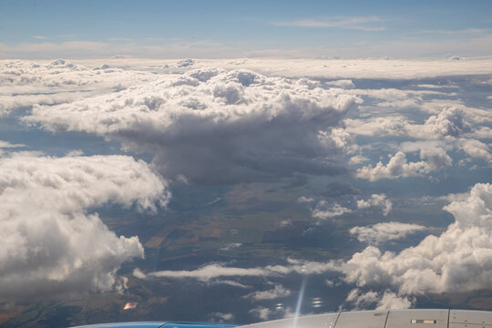 View From The Window Of An Airplane, On A Plane Taking Off, On A Beautiful Cloudy Sky. Airplane Or Plane Window With Wing And Cloudy Sky Behind