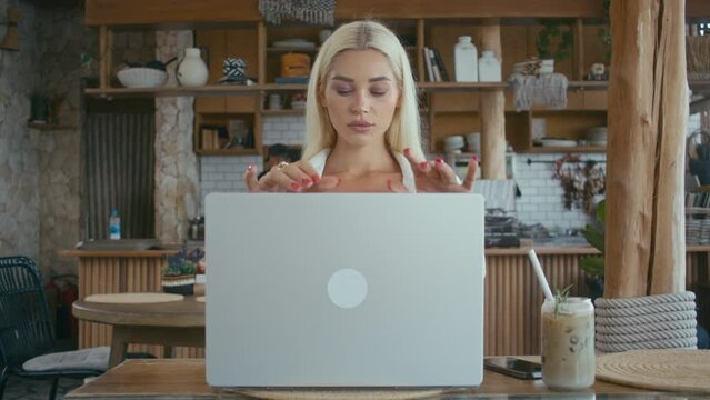 Beautiful Ukrainian blonde girl opening laptop computer. Pretty blonde woman starts working on notebook