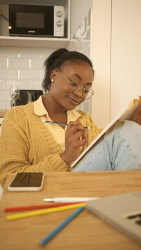 Vertical video of young African American female student studying at home.