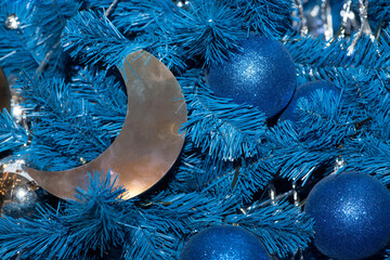 Blue and silver christmas balls, silver crescent moon on a blue christmas tree