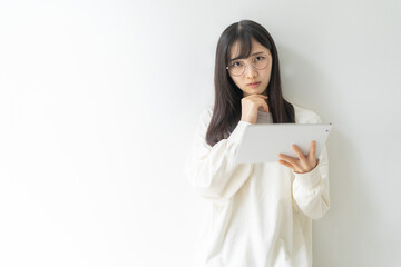 タブレットを持ち考える女性