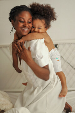 Happy black mother carrying girl on back