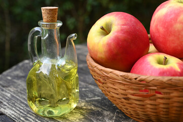 Carafe de vinaigre de pomme avec une corbeille de pommes en gros plan