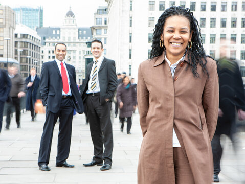 London Professionals, Business Woman. A mature black businesswoman leading her diverse team on the City streets. From a series of related images.