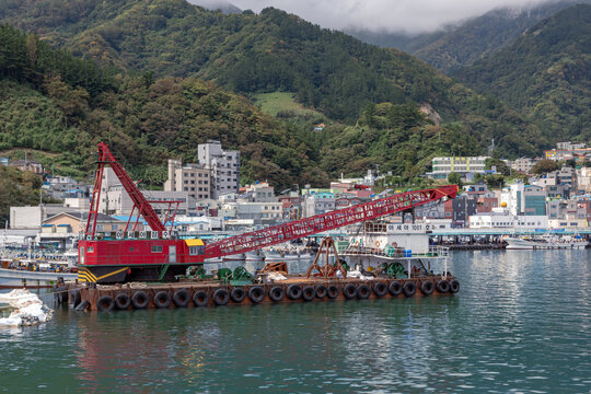 Red boats and mountain and green forest with a city village harbor view at Ulleungdo Island South Korea