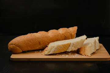 Sliced white bread lies on a cutting board on a wooden background