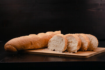 Sliced white bread lies on a cutting board on a wooden background