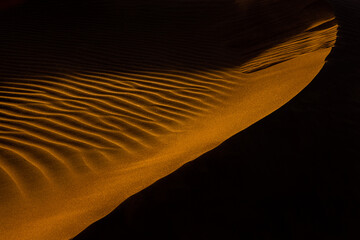 Close up orange sand texture in Empty Quarter Desert in United Arab Emirates. Sand dunes. Abstract sand texture in sunset light.