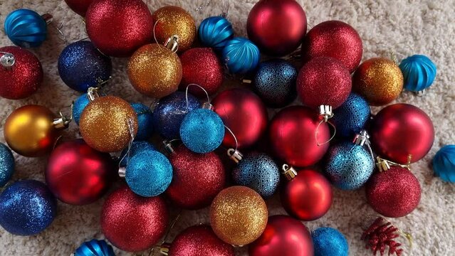 Christmas multicolored orange, red , silver and blue balls falling in slow motion and close-up zoom out. Preparing celebration. High quality 4k footage
