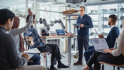 University Robotics Lecture: Teacher Explaining Engineering to Students by Using Robot Arm. Diverse...