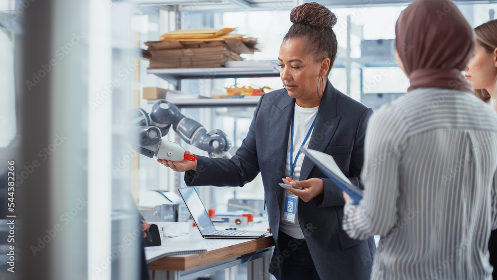 Leinwandbilder Diverse Computer Science Specialists and Black Mentor Looking at Robot Hand and Discussing It While Developing Innovative Programs. Robotics Technologies For Different Industries Concept.