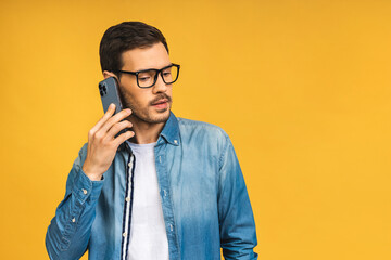 Oh, great news! Smiling young bearded casual man in glasses talking on the mobile phone isolated...