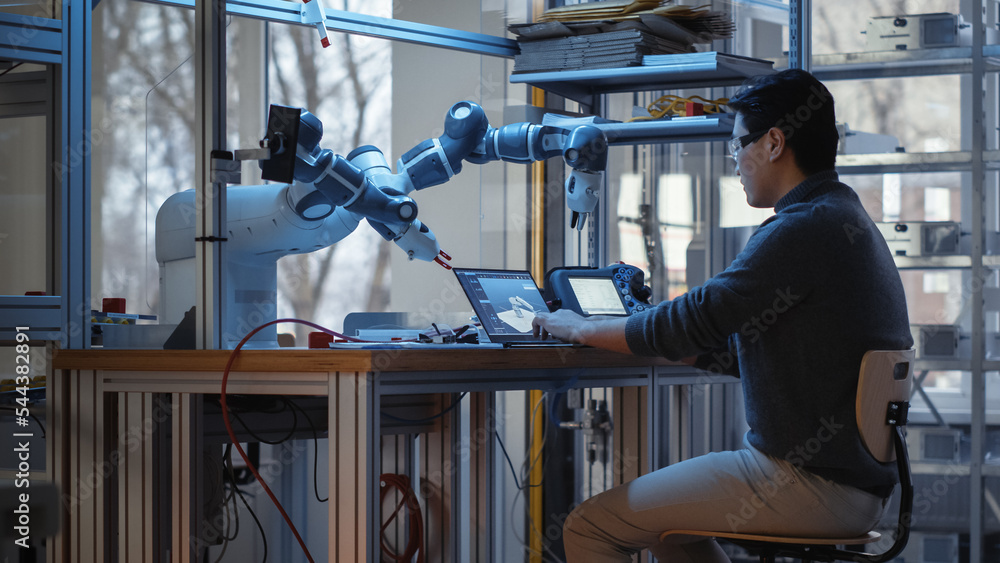 Poster Professional Young Developer Coding on Laptop and Manipulating Robotic Arm During Factory Workshop. People Designing Automated Robotic Systems for Facilities. Innovative Startup Company Concept.