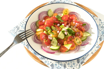 Freshly prepared healthy vegetable salad on a white dish.
