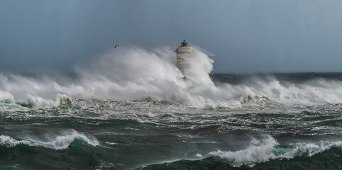 The lighthouse of the mangarche of calasetta in southern sardinia submerged by the waves of a stormy sea