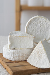Different geometric forms of camamber cheese. Multiform cheese camamber brie composition. Selective focus