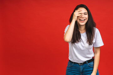 Portrait of happy smiling brunette business girl woman in casual isolated over red background.