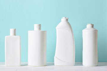 Plastic white bottles on a light blue background. Layout of bottles with household chemicals for cleaning and disinfection of the room
