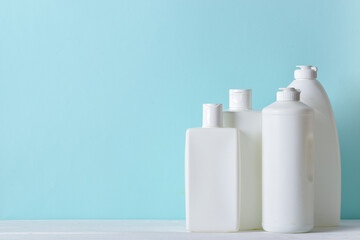 Four plastic white bottles on a light blue background.
