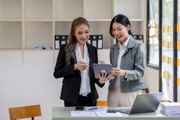 Entrepreneur Two Asian business discussing new business project in tablet in modern meeting room,  business plan investment, finance analysis concept.