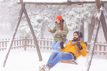 Couple swinging while on winter vacation