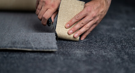 Obraz na płótnie Canvas Handyman cutting a new carpet with a carpet cutter...