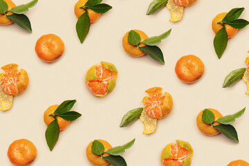 Ripe fresh orange yellow tangerines with green leaves, whole and peeled on beige background, trendy pattern. Citrus fruits mandarins, still life aesthetic photo, creative layout, vegan food