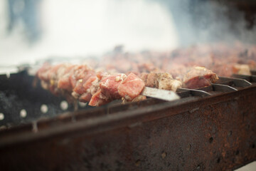 Frying meat on fire. Meat strung on blade. Outdoor kitchen.