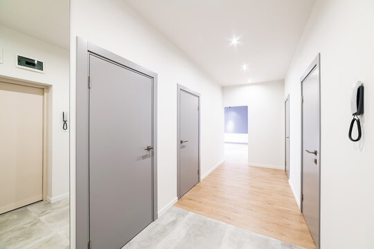 White corridor in the house with gray doors
