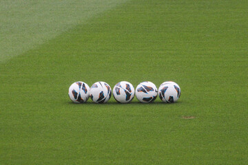 Balones de futbol sobre terreno de futbol.