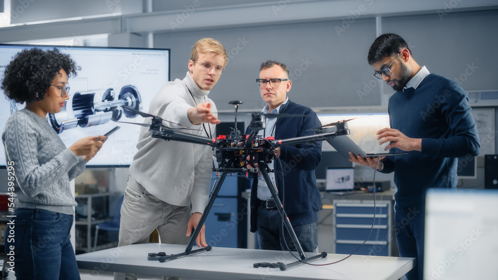 Aufkleber diverse aviation engineers work together on a new remote control drone, have active discussion, use 