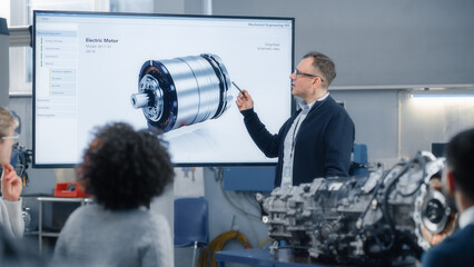 Professor Lectures Diverse Group of Multi Ethnic Students and Pointing at 3D Model of Turbine...