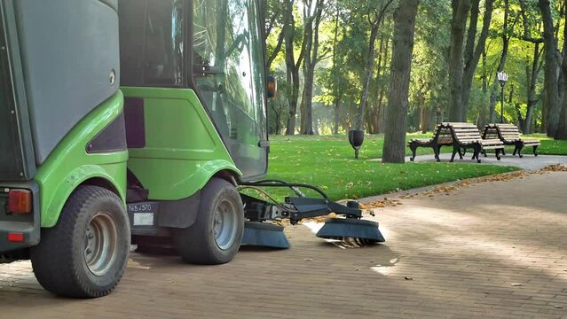 sunny morning in the city park
communal services clean the cobblestones using a small sweeper with cleaning brushes
the concept of urban improvement