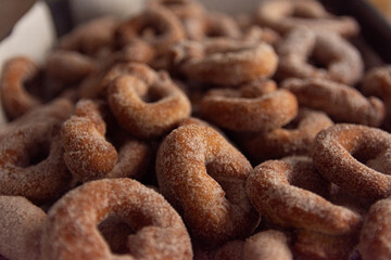freshly finished handmade spanish christmas donuts with icing sugar - close up view - landscape orientation