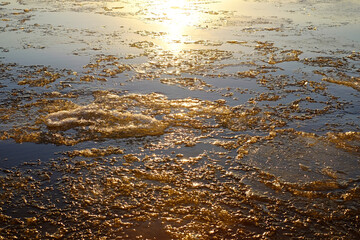 Sea with cracked ice at sunset, winter time