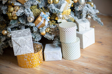 Christmas presents under the Christmas tree. New Year's and Christmas. Wrapped Gift. Beautiful packaging. Ribbon and bow on the packaging.