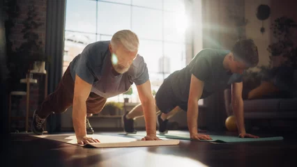 Tuinposter Middle Aged Man Exercising at Home with Personal Trainer. Senior Male Strengthening Body Muscles with Push-Ups Workout. Son Training with Sporty Father, Motivating Each Other to Be in Better Shape. © Gorodenkoff