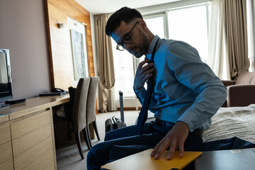 Tired businessman finally checks in the hotel room after all day discussing and talking at the...