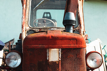 Old and shabby agriculture machine. Details of an old, red tractor. 