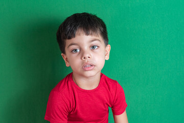 Kid in red t-shirt on the green background