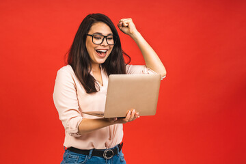 Portrait of attractive surprised excited smiling business woman hold hand up looking at laptop...