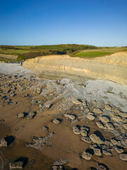 Aerial view of limestone cliffs and a rock covered sandy beach