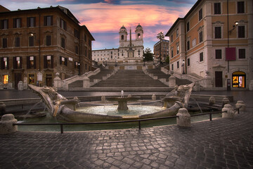 The Fontana della Barcaccia, at sunset, is a fountain found at the foot of the Spanish Steps in...