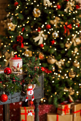  Christmas composition with a candy bowl and a red ball on the table against a background of blurred lights
