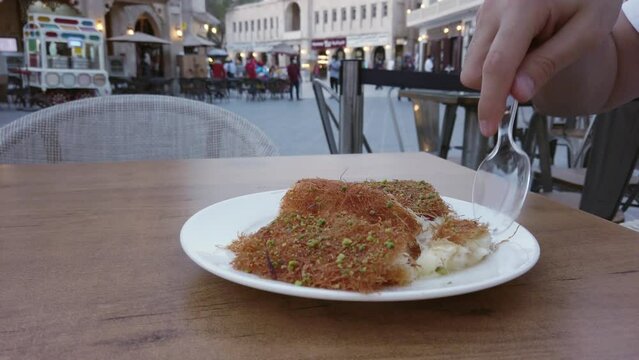 Turkish dessert kunefe, kunafa, kadayif with pistachio powder and cheese, served hot, very sweet