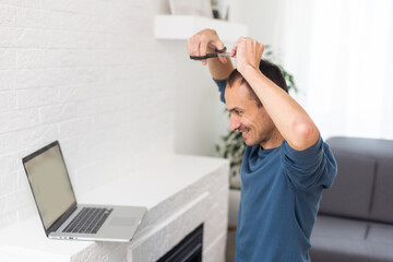 a man looks at a haircut on a laptop, online hairdressing tutoring on a laptop