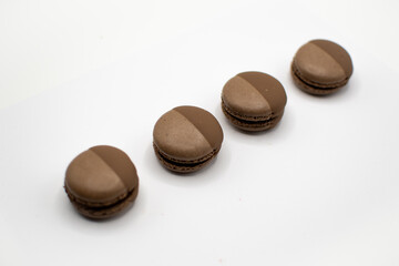 Obraz na płótnie Canvas Braune Macarons in Schokolade gedippt, im Set, schräg von oben